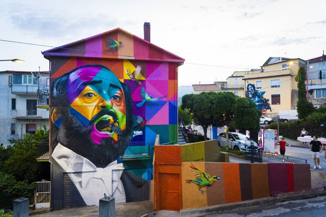 Murale colorato street art con volto geometrico e uccelli